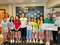  Kenmore East students and staff pose with a $5,000 check for Kids Escaping Drugs.